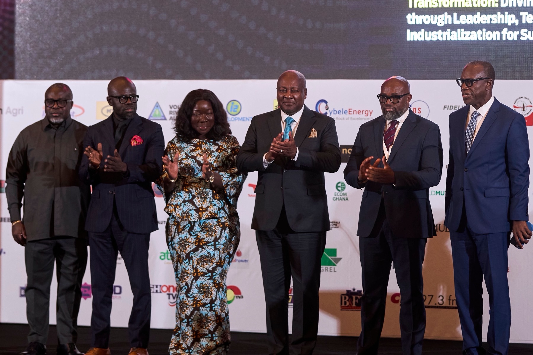 Dignitaries applauding on stage beneath the summit theme