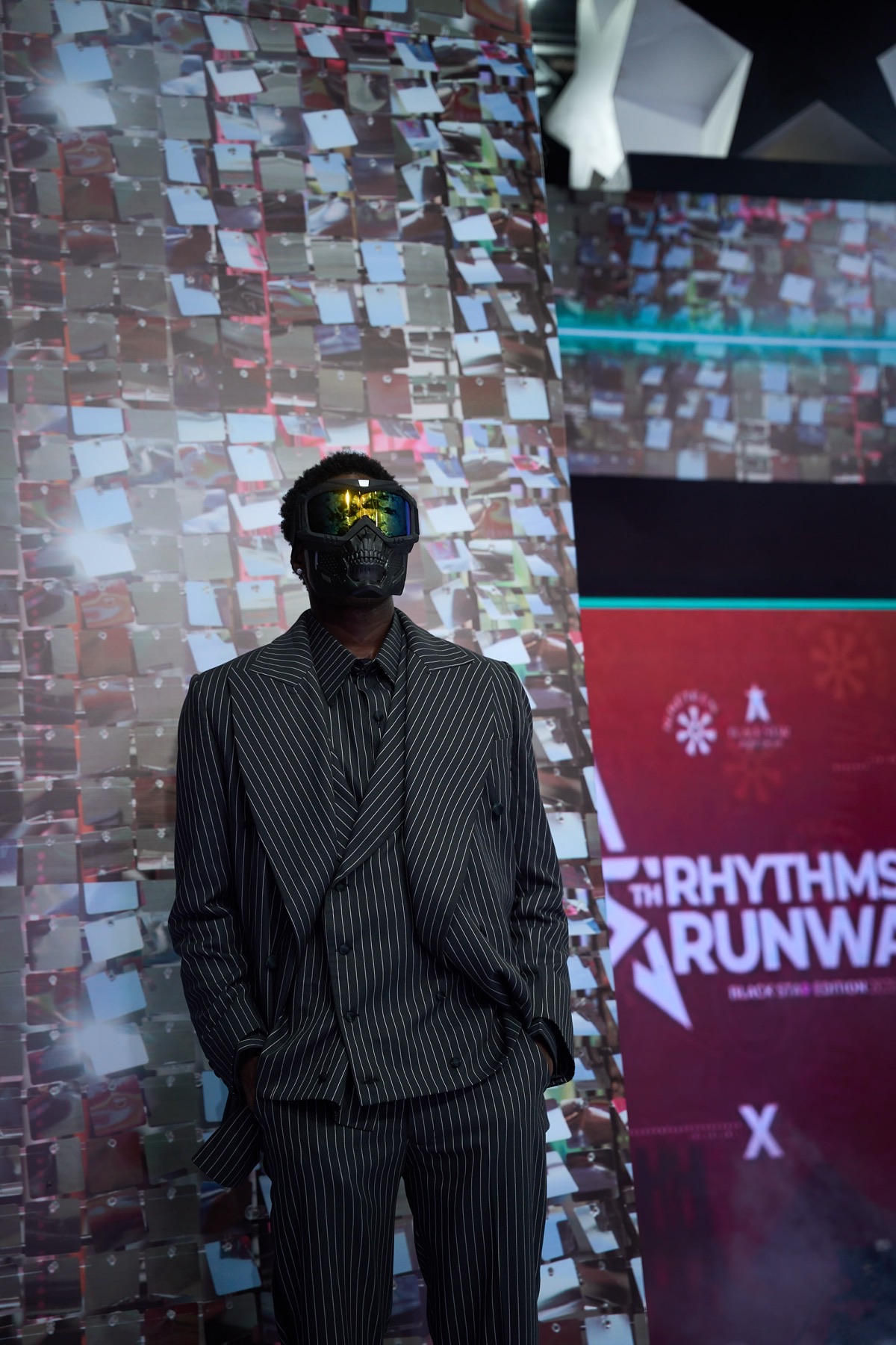 A masked model in pinstripe against the Black Star Edition set
