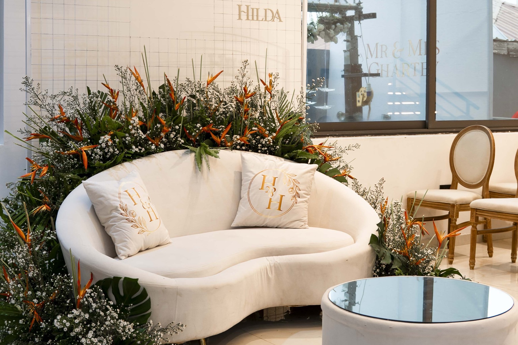 A styled lounge seat framed by tropical florals