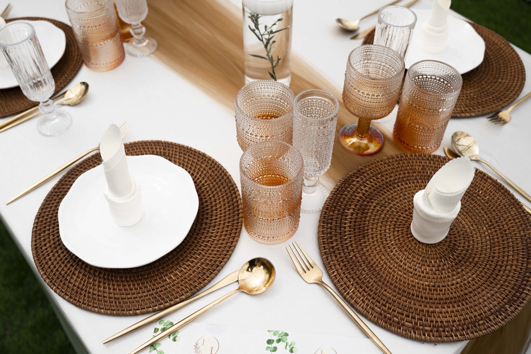 Place settings with rattan chargers and gold cutlery